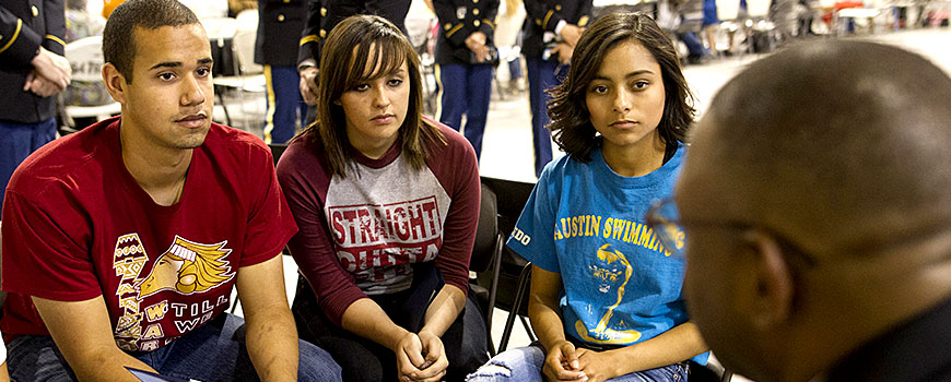 Three youth listening to a speaker