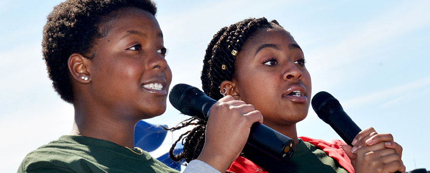 two youth holding microphones